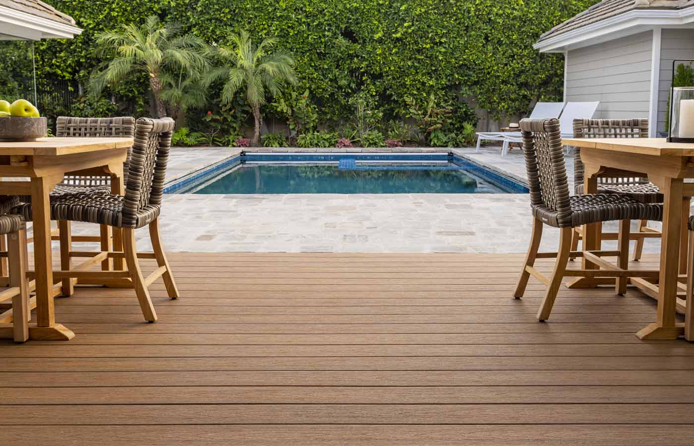 Pool deck made with stone pavers, paired with a composite decking outdoor living space