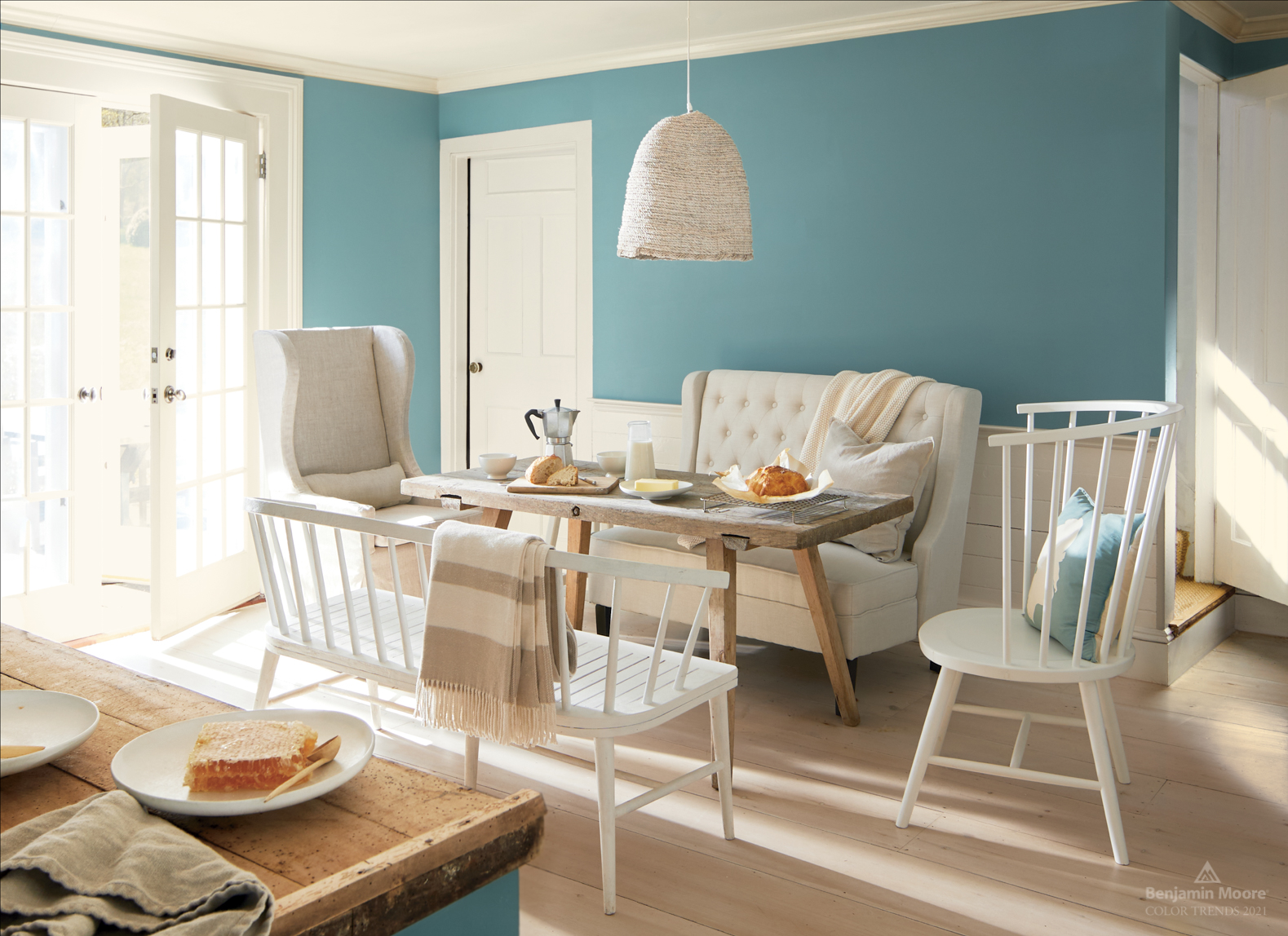 Sunlit breakfast room in Benjamin Moore Aegean Teal with natural light wood textures