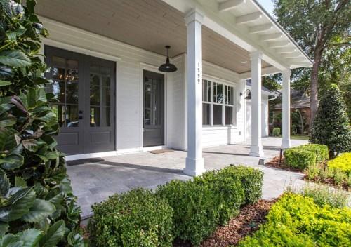 Home exterior with warm white paint and front door in Benjamin Moore Kendall Charcoal