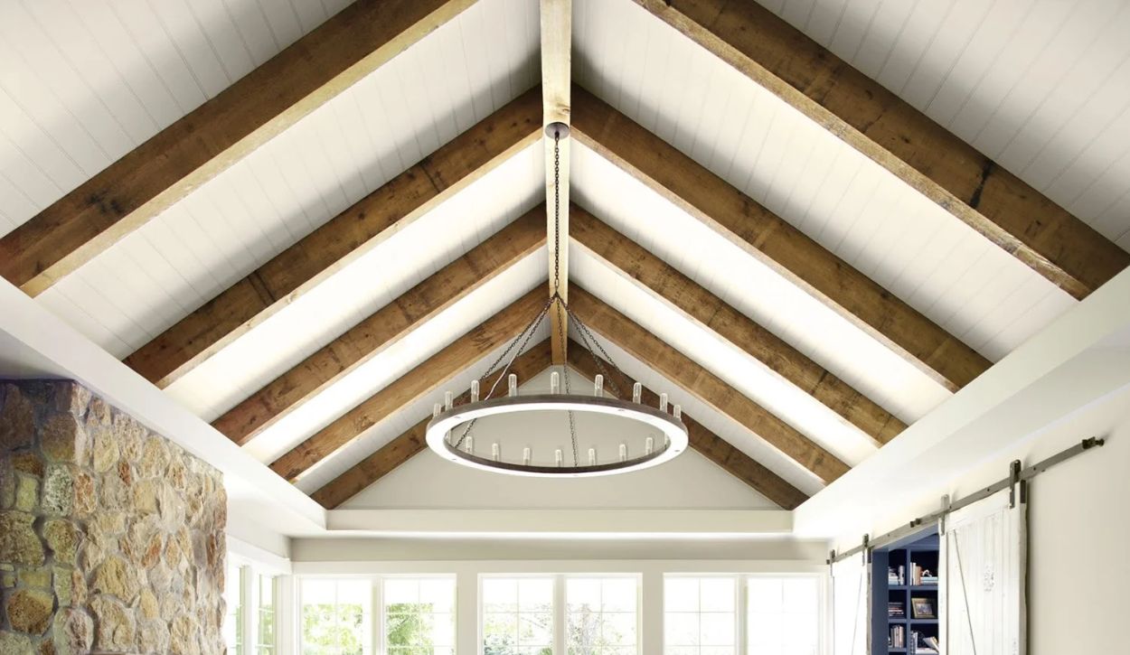 Living room with exposed wooden beams and vaulted ceiling painted in Benjamin Moore Pale Oak