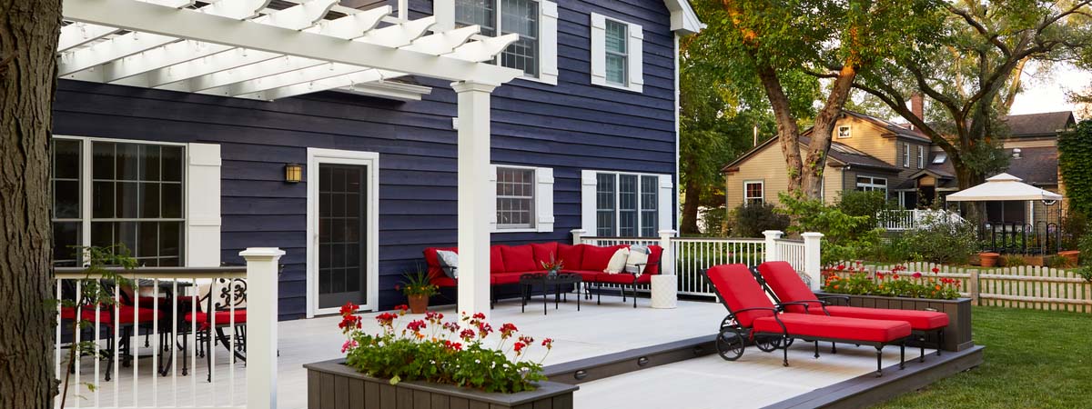 Low gray multi-level deck with a pergola over half of it; Timbertech Advanced PVC Deck Color: Whitewash Cedar; Railing: Classic Composite Series - Drink Rail