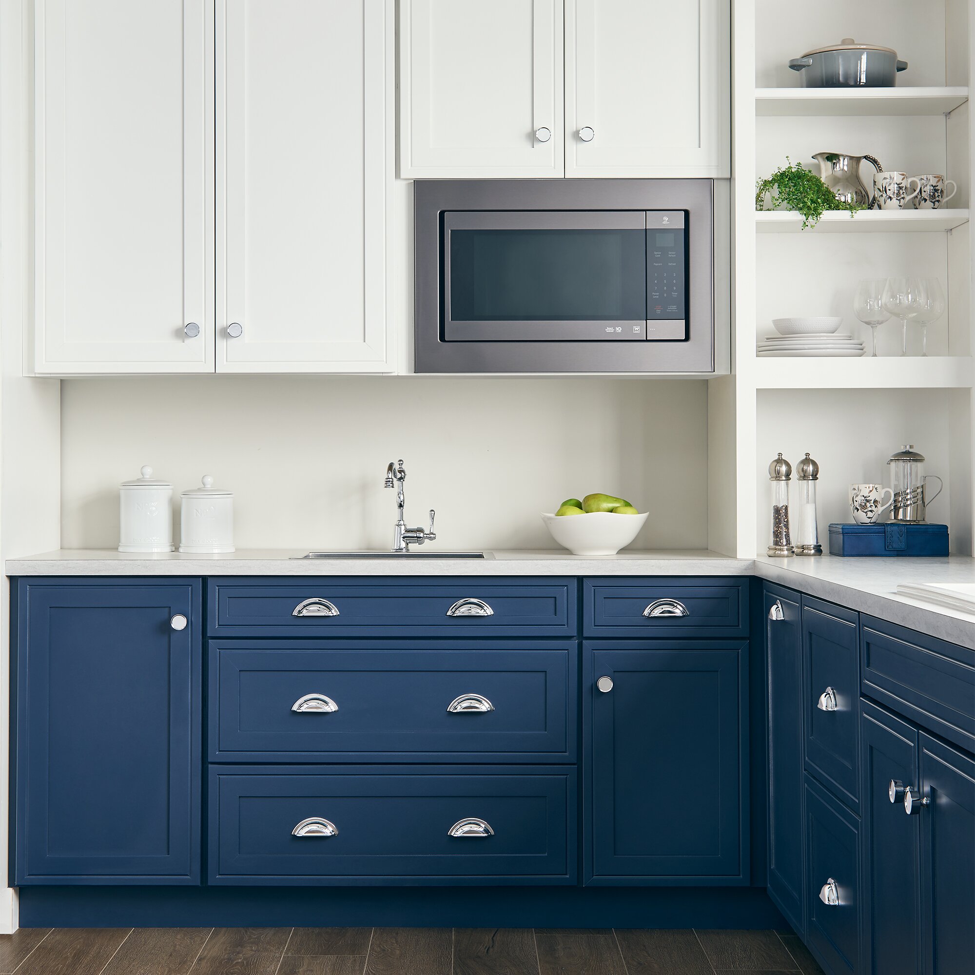 Kitchen with white upper cabinets, blue lower cabinets, and chrome knobs and pulls