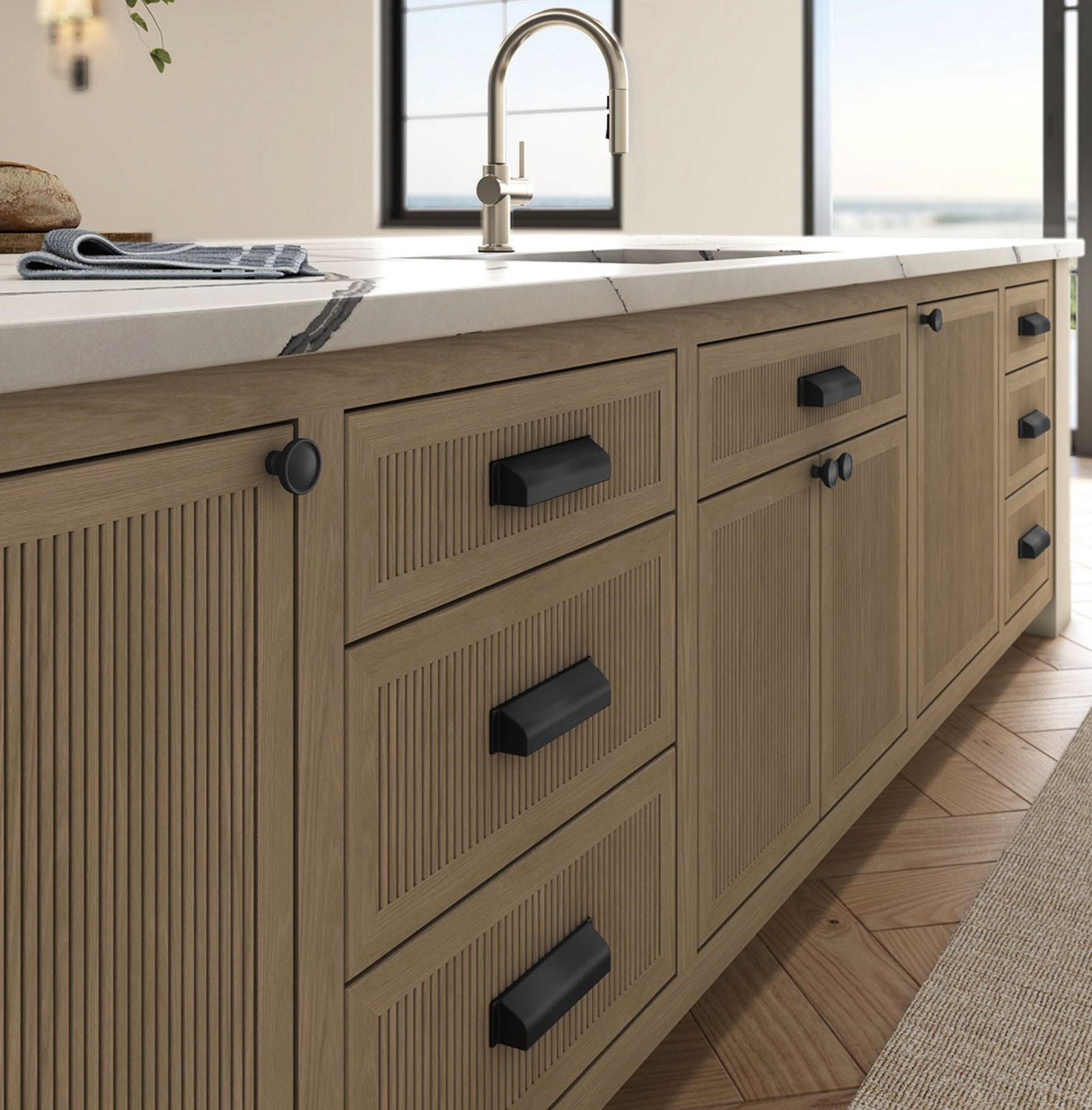 Kitchen with light wood cabinets and black satin cup pulls and knobs by Baldwin Hardware