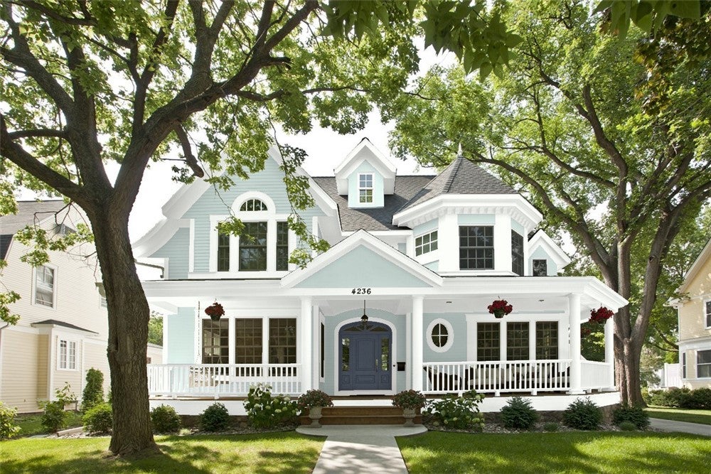 Home with a cool color palette featuring Benjamin Moore’s Woodlawn Blue on the siding, cool white trim painted in Chantilly Lace, and Hale Navy on the front door.